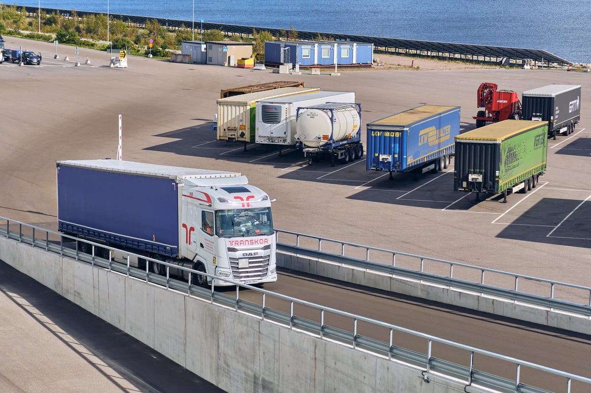 White DAF cab-over truck with blue trailer, European flat-nose transport truck