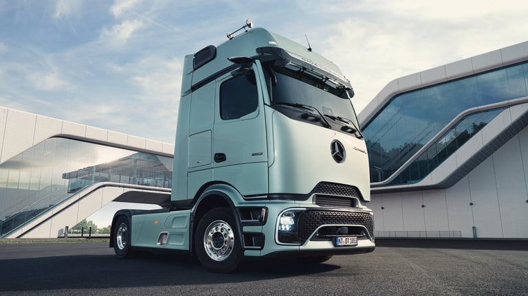 Light blue modern semi-truck cab parked in front of modern industrial building